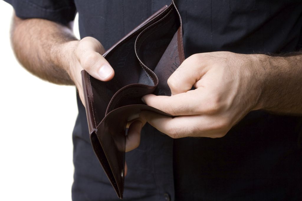 Hombre abriendo su cartera en la que no hay dinero