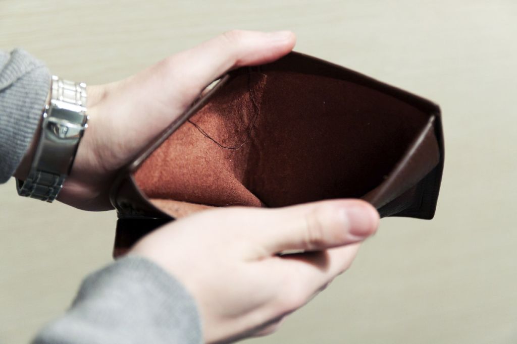 Hombre abriendo una billetera sin dinero