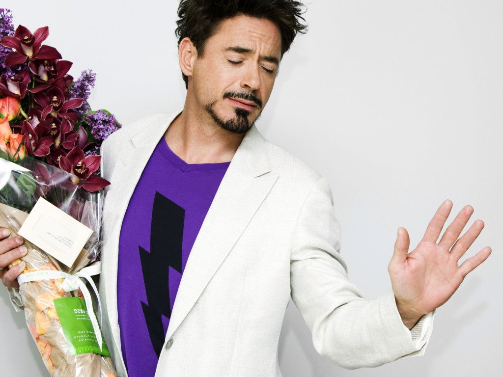 Robert Downey Jr. con los ojos cerrados y un ramo de flores en la mano