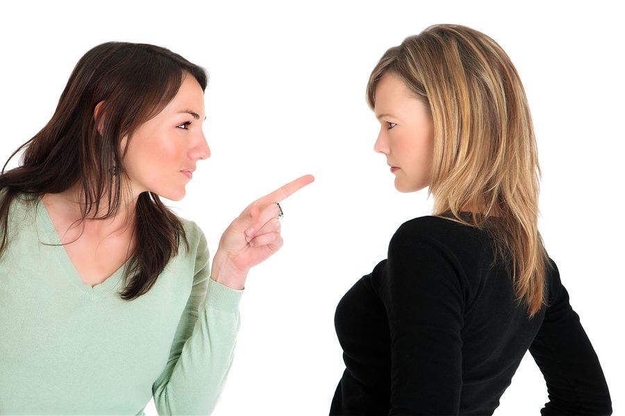 Una mujer enfadada señalando con el dedo a otra mujer también enfadada