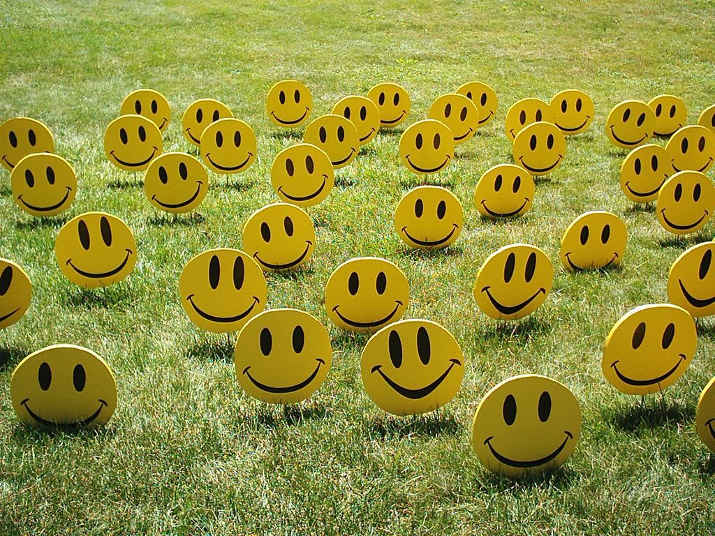 Varias caritas amarillas sonrientes en un cesped