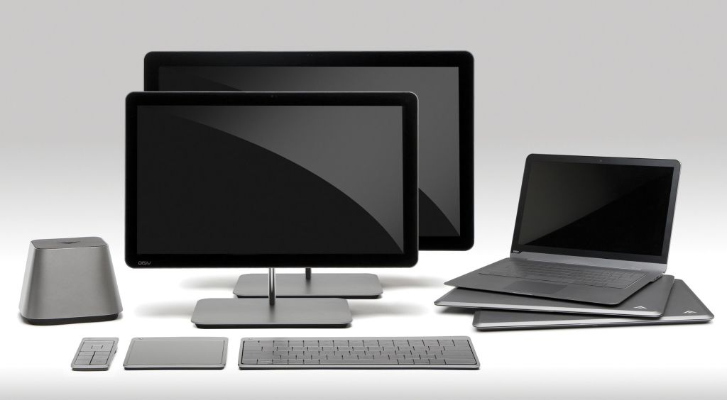 Dos pantallas de ordenador con un teclado y tres portatiles al lado