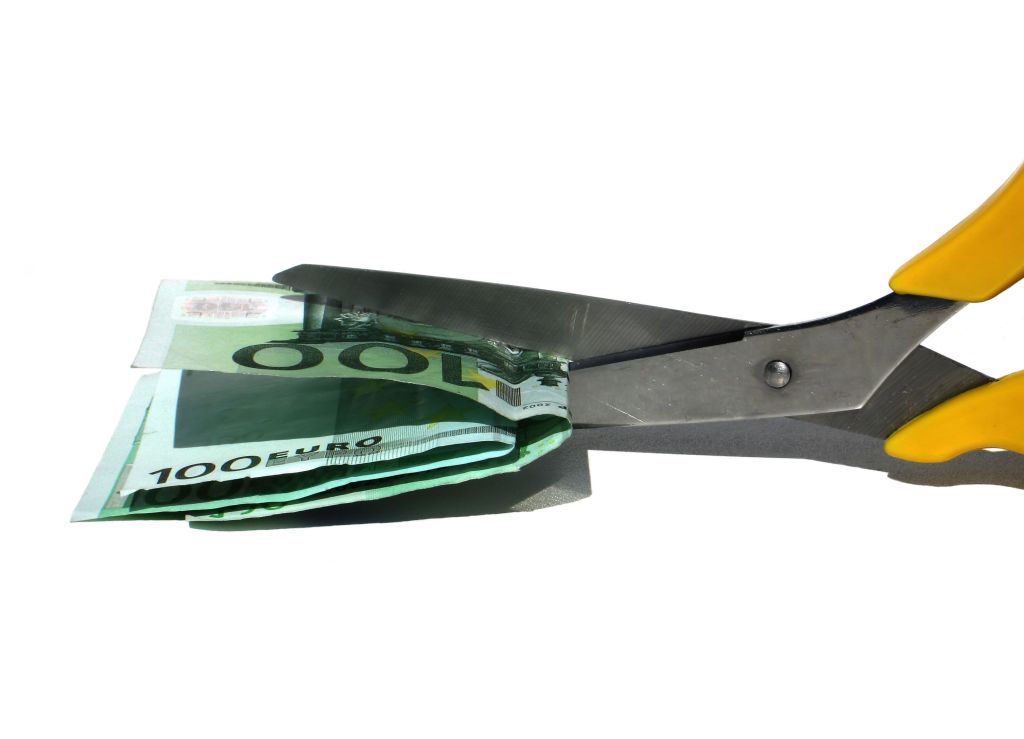 Tijeras cortando varios billetes de euro