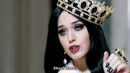 Gif de Katy Perry con una corona diciendo adios con la mano