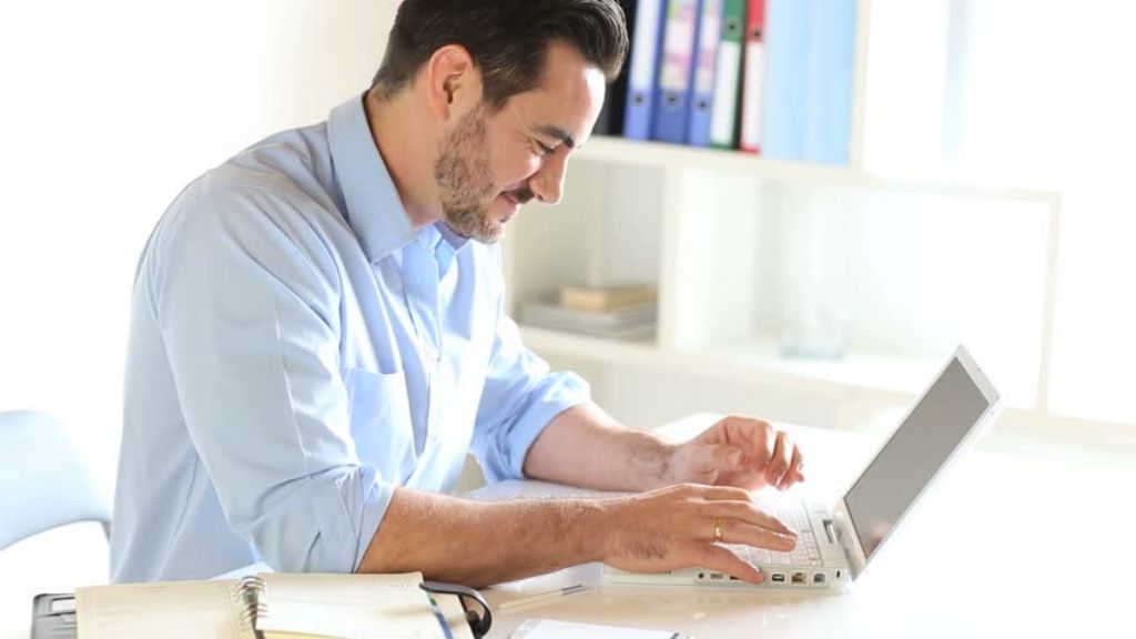 Hombre mirando su portátil para pedir un préstamo online
