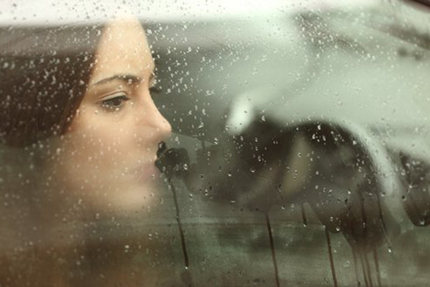 Mujer viendo por la ventana de un auto