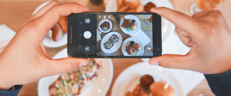 Tomando una fotografía a varios platos de comida con un smartphone