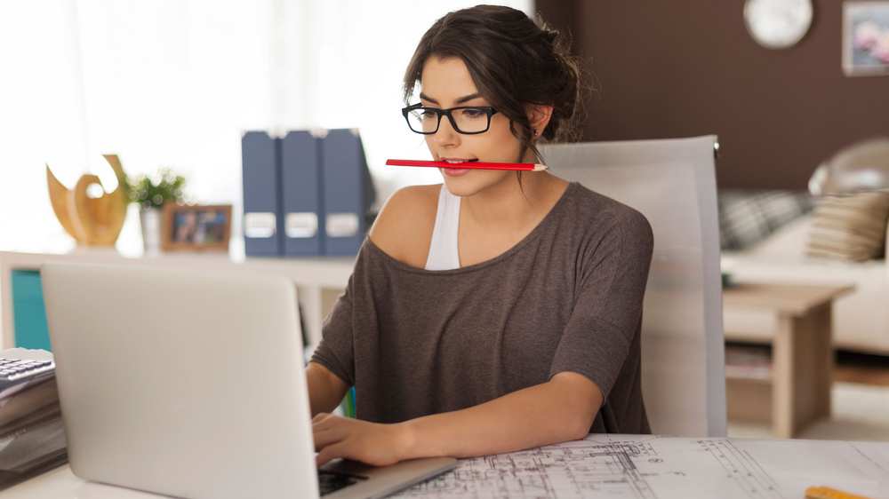 mujer trabajando con lápiz rojo en la boca