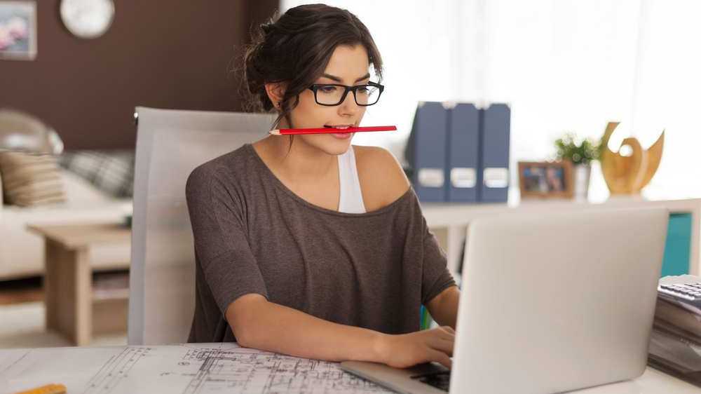 mujer trabajando con lápiz rojo en la boca