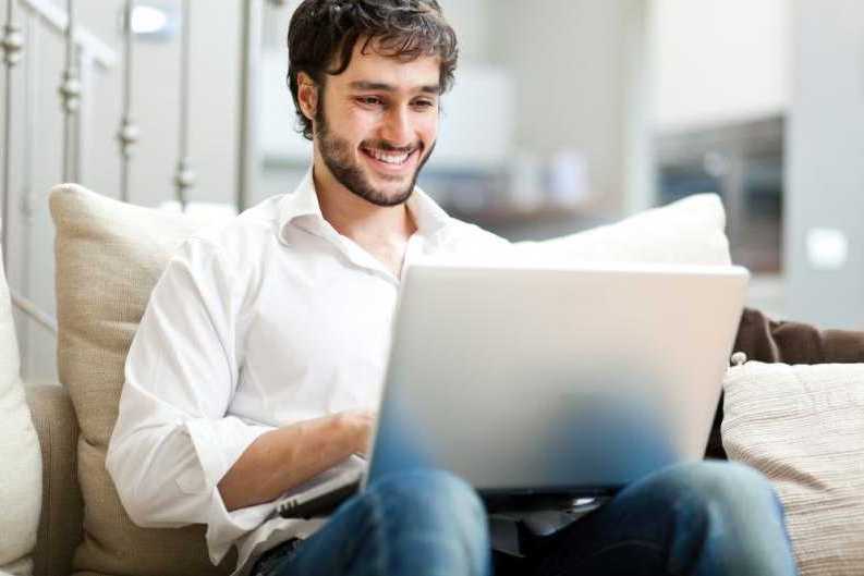 Hombre en portátil contento navegando online