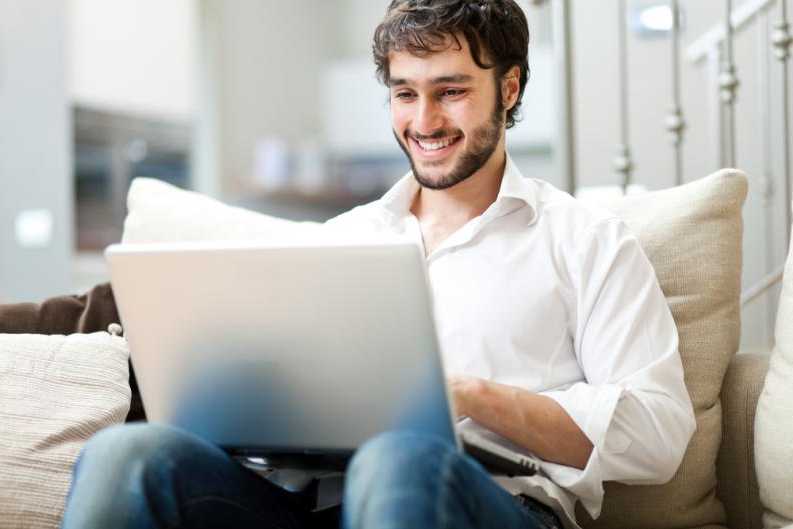 Hombre en portátil contento navegando online