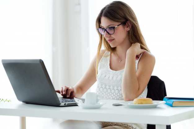 mujer trabajando en escritorio con su laptop
