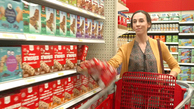 Mujer tirando cajas en carrito de supermercado
